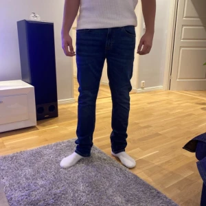 Blå jeansbyxor - Snygga blå jeansbyxor med normal passform och midwaist. Perfekta för en avslappnad stil. Klassisk design med fem fickor och knappgylf.