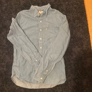 Blå jeansskjorta från Levi's - Snygg blå jeansskjorta från Levi's med klassisk krage och bröstficka. Passar bra på någon som är 170-185 skick 9/10 säljer för endast 149!