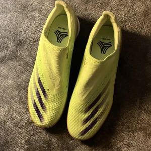 Gula fotbollsskor från Adidas - inomhus fotbollsskor från Adidas. Skorna har en strömlinjeformad design och är perfekta för inomhusspel. De har en slitstark gummisula och kommer med extra skosnören. Har än vänt dom en gång inomhus köpte dom för 1199