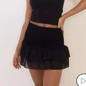 Svart volangkjol - Trendig svart kortkjol med volangdetaljer. Perfekt för att skapa en chic look. Kjolen har en elastisk midja för bekväm passform. Skriv för fler bilder,pris går att diskutera💕
