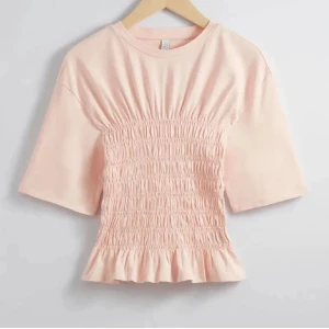 Ljusrosa topp med smockdetaljer - Säljer min fina topp från &otherstories i storlek. Xs, tröjan är stresig och passar även de som brukar ha storlek S. Tröjan är andvänd ett fåtal gånger och har inga tecken på andvändning.💕 