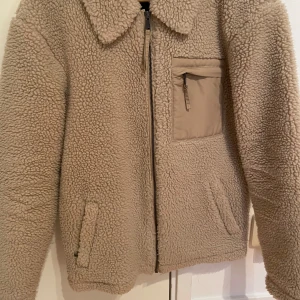 Beige teddyjacka från New Look - Mysig beige teddyjacka från New Look med dragkedja. Fint skick!