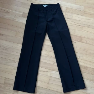 Svarta kostymbyxor från Madlady - Snygga svarta kostymbyxor från Madlady med en klassisk rak passform. Perfekta för en stilren look. Byxorna har en hög midja och är tillverkade i ett elegant material.