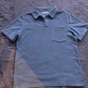 Ljusblå frotté t-shirt från Studio Total - Säljer en ljusblå frotté t-shirt från Studio Total. Den har en klassisk krage och en bröstficka. Perfekt för en avslappnad stil.