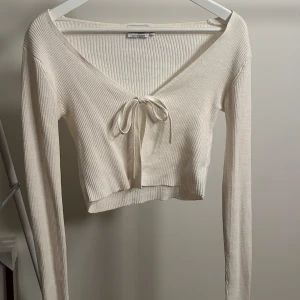 Beige ribbad tröja från NA-KD - Superfin ribbstickad beige kofta med snörning från nakd💓 Använd ca 2 ggr så den är i fint skick!!  Tveka inte på att skriva vid frågor✨
