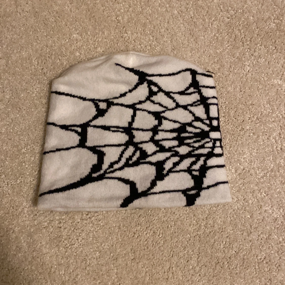 Vit mössa med spindelnätsmönster