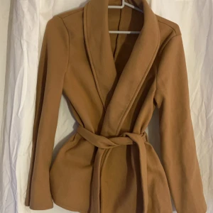 Beige kappa med knytband - Väldigt tunn så passar inte nu på vintern. Använd ett fåtal gånger.