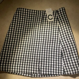 Svartvit rutig kjol - En rutig kjol storleken XS. Kjolen har en kort längd och passar bra till olika tillfällen. (Tar bara emot swish)