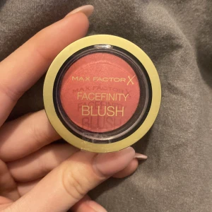 Max Factor Facefinity Blush i nyansen Sunkissed Rose - Max Factor Facefinity Blush i nyansen Sunkissed Rose. En kompakt rouge med en varm, rosig ton. Förpackningen är rund med en genomskinlig topp och en guldfärgad kant.
