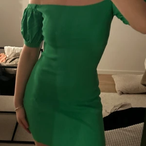 Grön  klänning - Trendig grön klänning med offshoulder-design och kort ärm. Perfekt för en sommaren! Klänningen är från zara och har aldrig haft på mig den! I storlek S