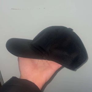 Svart keps - Snygg svart keps med justerbar rem baktill. Perfekt för en casual look och skydd mot solen. Enkel och stilren design som passar till det mesta. Äkta!!