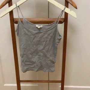 Grå linnetopp från River Island - Säljer en stilren grå linnetopp från River Island. Toppen har smala axelband och en enkel design som passar perfekt till vardags. Storlek dam xxs, vilket motsvarar EUR 32.