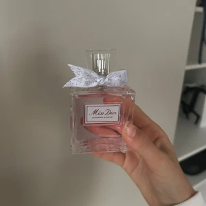 Miss Dior  - Jättehärlig miss dior parfym i doften blooming bouquet 💞 100 ml, aldrig använd, bara luktad på! Köpte på en flygplats, har inte kvitto men kan skicka fler bilder vid intresse. Flaskan är dekorerad med en söt rosett och har en ljusrosa vätska. Perfekt för den som älskar en fräsch och blommig doft.
