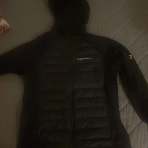 Svart dunjacka från Peak Performance - M men passar ochså L Snygg svart dunjacka från Peak Performance med dragkedja framtill. Perfekt för kyliga dagar med sin quiltade design och långa ärmar. Diskret logga på bröstet och ärmen. Köpt för 2500