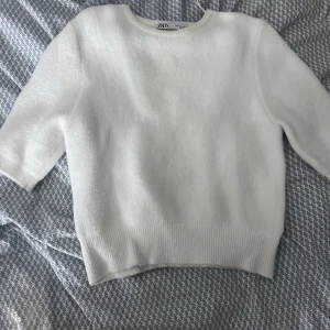 Vit tröja från Zara - Säljer en stilren vit tröja från Zara. Tröjan har en rund halsringning och trekvartsärmar, perfekt för en minimalistisk look. Materialet känns mjukt och bekvämt. Stl m men skulle säga att den passar dom som bär xs och s bäst men även m beroende på hur man vill att den sitter