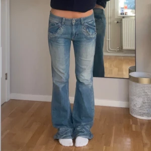 Blå lågmidjade bootcut jeans - Snygga blå bootcut jeans med låg midja från Nouvelle Jean, i mycket bra skick. Midjemått:40cm rakt över Innerbensmått:80cm