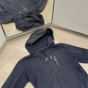 Sail Racing Kofta - Säljer en marinblå hoodie från Sail Racing i mycket bra skick lite solblekt men inga större besvär än så. Den har en dragkedja framtill och en praktisk huva. Perfekt för kyliga dagar och passar till både vardag och fritid. Storlek M.