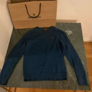 Morris tröja - Säljer en snygg, stickad blå tröja från Morris i 100% merinoull.  Kommer i originalpåse och allt tillbehör kommer med. Den är i storlek XS och passar någon som är ca 170cm. Vid funderingar är det bara och fråga på. Kom dm för fler bilder. Priset är ej hugget i sten!