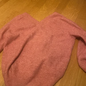 Rosa stickad tröja - Mysig rosa stickad tröja i bra skick. Perfekt för kyliga höst- och vinterdagar. Tröjan har långa ärmar och en bekväm passform. Den är enkel men stilren, vilket gör den lätt att matcha med olika outfits.