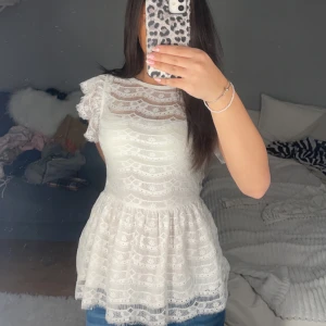 Vit spetsblus med volangdetaljer - Säljer en superfin vit spetsblus med volangdetaljer på ärmarna. Passar både till vardags och festliga tillfällen! Säljer då den inte kommer till användning, bara att dm:a vid frågor eller funderingar!💕 Pris kan diskuteras!!