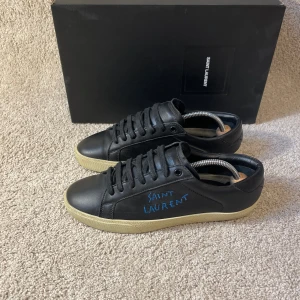 Saint Laurent skor  - Svarta saint Laurent skor med blå text, storlek 39 men passar upp till 40-40,5, skopåse & kort ingår.