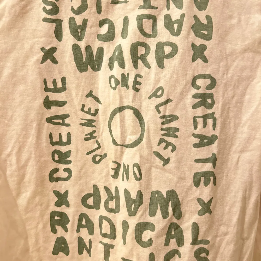 Säljer en vit t-shirt med grönt tryck på både fram- och baksidan. Texten säger 'One Planet' och 'Create Radical Antics'. Perfekt för en avslappnad stil och gjord i mjukt material. Passar bra till vardags eller chillhäng. Använt något gång köpt längesen.. T-shirts.