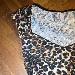 Snygg leopardmönstrad topp i storlek XXS. Den har en v-ringad hals och korta ärmar, perfekt för en utekväll eller fest. Materialet känns mjukt och bekvämt mot huden. Ett måste för dig som älskar djurmönster!