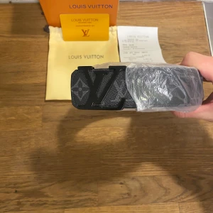  Louis Vuitton bälte - Säljer ett snyggt svart Louis Vuitton bälte i skinn med det klassiska LV-mönstret. Bältet har en stilren svart spänne med LV-loggan. Perfekt för att ge din outfit en lyxig touch. Kommer med originalförpackning och kvitto.                                          Skriv vid minsta fråga eller fundering🔥👍