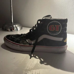 Svarta sneakers med GT-märke - Säljer ett par coola svarta sneakers med högt skaft och GT-märke på sidan. Skorna har vita detaljer och snörning framtill. De är i bra skick och perfekta för en avslappnad stil. Passar både till vardags och festliga tillfällen .Säljer pågrund av att jag växte ut de bra skick men lite smutsiga men ingen man inte kan tvätta bort storlek 41
