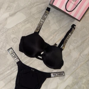Svart set från Victoria's Secret - Snygg svart bikini set från Victoria's Secret med glittriga detaljer på axelbanden och midjan. Materialet känns lyxigt och bekvämt mot huden.