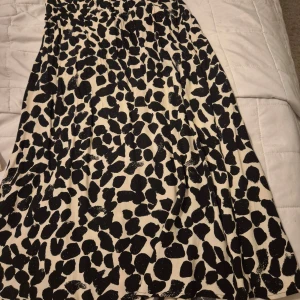 Svartvit mönstrad kjol - Säljer en superfin svartvit kjol med ett coolt leopardmönster. Perfekt för både vardag och fest! Kjolen har en bekväm passform och är gjord i ett mjukt material som känns skönt mot huden. Den är lätt att matcha med både enkla toppar och mer dressade blusar. Ett måste i garderoben! 🖤🤍