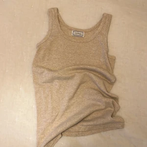 Beige linnetopp från By Malene Birger - Säljer en stilren beige linnetopp från Malene Birger. Perfekt för sommardagar eller som ett basplagg i garderoben. Toppen är ärmlös och har en klassisk rund halsringning. 100% bomull