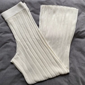 Vita ribbade byxor stl M - Säljer ett par superbekväma vita ribbade byxor. De är högmidjade och har en loose passform som är perfekt för en avslappnad stil. Materialet är mjukt och stretchigt, vilket gör dem idealiska för både hemmamys och vardagsbruk. Perfekta för höst och vår!