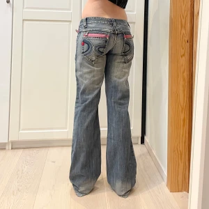 Lågmidjade bootcut jeans med snygga detaljer💕 - Midja 41 cm rakt över och innerben 84 cm jae 169 o xs-s för referens🤩ej slitet vid hälarna designen ser bara ut sån!!