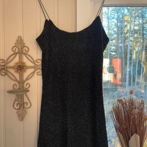 Svart glittrig klänning från NLY Design - Snygg svart glittrig klänning från NLY Design i storlek S. Det är tunna axelband.  Har använts några gånger bara