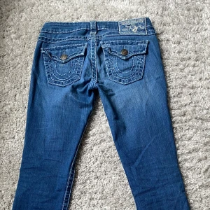 True religion jeans  - Säljer mina lågmidjade bootcut true religion jeans💕   Midjemåttet rakt över:39cm Innerbenslängden:83cm De har inga defekter förutom några få saknade sömmar längst ned på vänstra benet (se bild 5) men inget som märks!❤️  Skriv för frågor eller bilder!