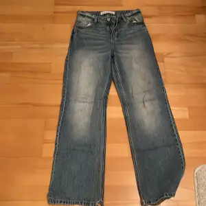 Säljer ett par snygga blå jeans från Bershka i storlek EUR 32. De har en klassisk femficksdesign och en cool, sliten look. Perfekta för en avslappnad stil och passar till det mesta. De är i bra skick och redo för en ny ägare! Lågmidjade!