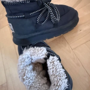 Svarta vinterboots från Zara - Mysiga och varma svarta vinterboots från Zara med fluffigt foder. Perfekta för kalla vinterdagar. De har snörning med mönstrade skosnören och en robust sula för bra grepp. Märket 'My Winter Boot' syns på sidan.