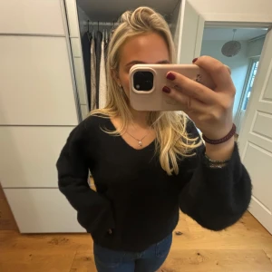 Svart tröja med v-ringning - Säljer en stilren svart tröja med v-ringning. Den är perfekt för både vardag och fest. Tröjan har långa ärmar och en skön passform som är lite loose. Passar bra till jeans eller kjol. Perfekt för höst och vinter! Gjord av Alpacka