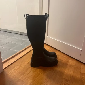 Svarta höga stövlar med dragkedja - Snygga svarta stövlar i skinn med en robust sula och dragkedja på sidan. Perfekta för höst och vinter. Använda 1 gång. Ordinarie pris 729kr. Från Even&Odd