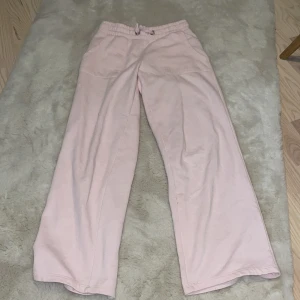 Rosa mjukisbyxor med snörning Ird pris150 - Supermysiga rosa mjukisbyxor i bomull med snörning i midjan. Perfekta för en chill dag hemma eller en snabb tur till affären. De har en loose passform och är riktigt bekväma. Passar perfekt till höst och vinter när man vill hålla sig varm och bekväm.