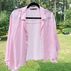 Rosa skjorta - En ljusrosa kortärmad skjorta från Zara 🌸 Skjortan är i storlek L och är superfin som overshirt över en mindre topp exempelvis. Fint oversized på mig som har storlek S 💞   (ALDRIG ANVÄND)  Längd: 54 cm Axel: 63 cm