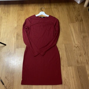 Röd ribbad klänning från BikBok - Säljer en snygg röd ribbad klänning från BikBok. Den är långärmad och har en enkel, men stilren design som passar perfekt för höst och vinter. Klänningen är i storlek L och är i nyskick. Perfekt för både vardag och fest!