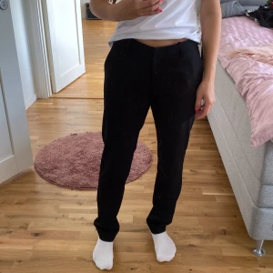 Svarta kostymbyxor från H&M - Säljer ett par stilrena svarta kostymbyxor från H&M i storlek 36. De är midwaist och har en klassisk straight passform. Perfekta för både jobb och festliga tillfällen. Byxorna är i bra skick och har en dragkedja framtill.