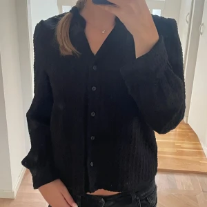 Svart blus - Svart blus med puffärm och knappar. Köpt på Vila men märket är Object. Knappt använd. 