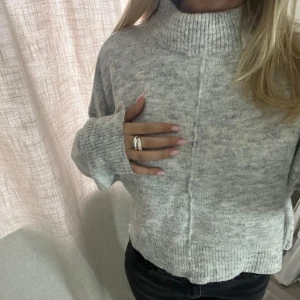 Grå stickad tröja från Gina Tricot - Säljer en supermysig ljusgrå stickad tröja från Gina Tricot. Den har en hög krage och långa ärmar . Tröjan är i storlek S 💘. Perfekt nu till hösten och vintern 🍁🍂