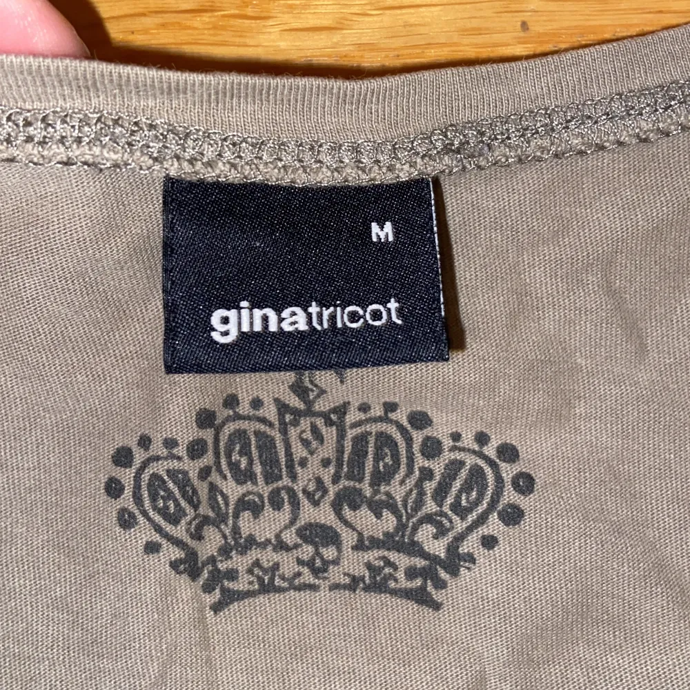 En cool olivgrön/gröngrå T-shirt från Ginatricot med ett snyggt tryck på.  Står att det är storlek M men skulle säga själv att den är storlek S. Skriv för mer info!☺️. T-shirts.