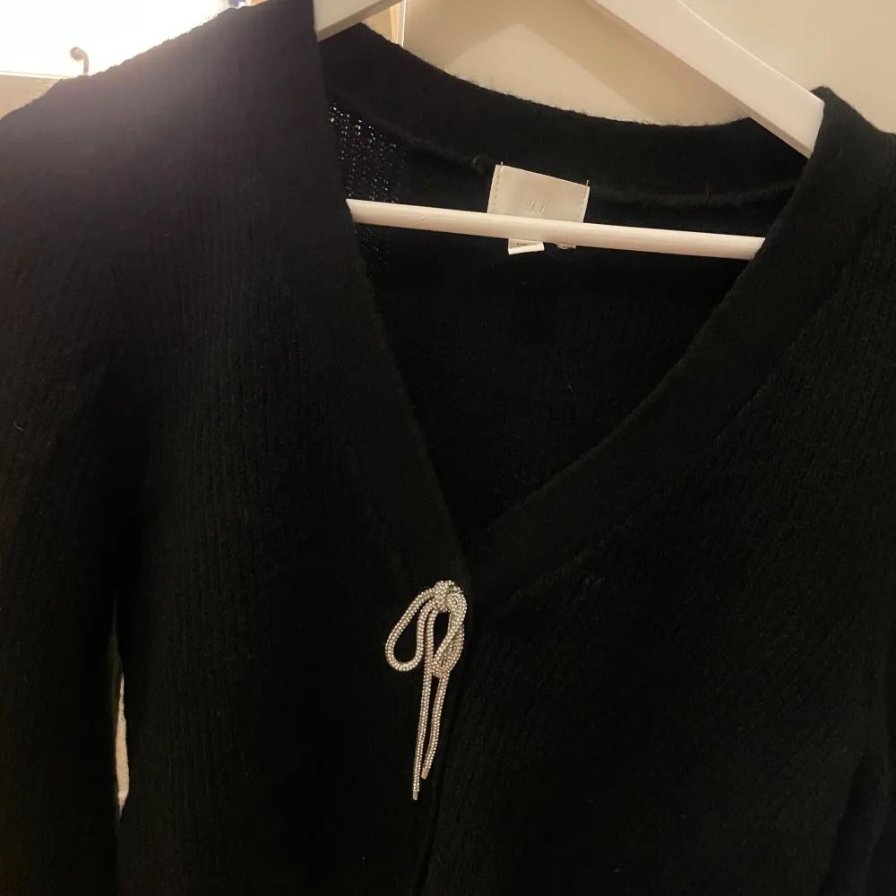Kofta med rosett i strass framtill. Superfint skick ifrån H&M.. Neuletakit & Villapaidat.