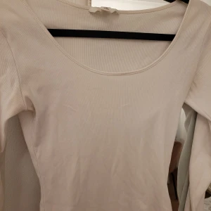  Vit ribbad topp från H&M - Säljer en stilren vit ribbad topp från H&M. Den har lite missfärgningar vid ena armhålan, men så svagt att man inte ser det. Säljer en lika dan i svart i storlek S.