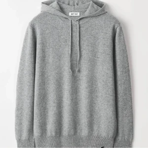 Grå hoodie från Soft Goat - Säljer en supermjuk och stilren grå hoodie från Soft Goat. Den är tillverkad i 100% kashmir och har en klassisk design, perfekt för kyliga dagar när du vill ha något både snyggt och bekvämt. Den är använd ungefär 20-25 gånger o e sparsamt använd, nypris ligger på 3500.